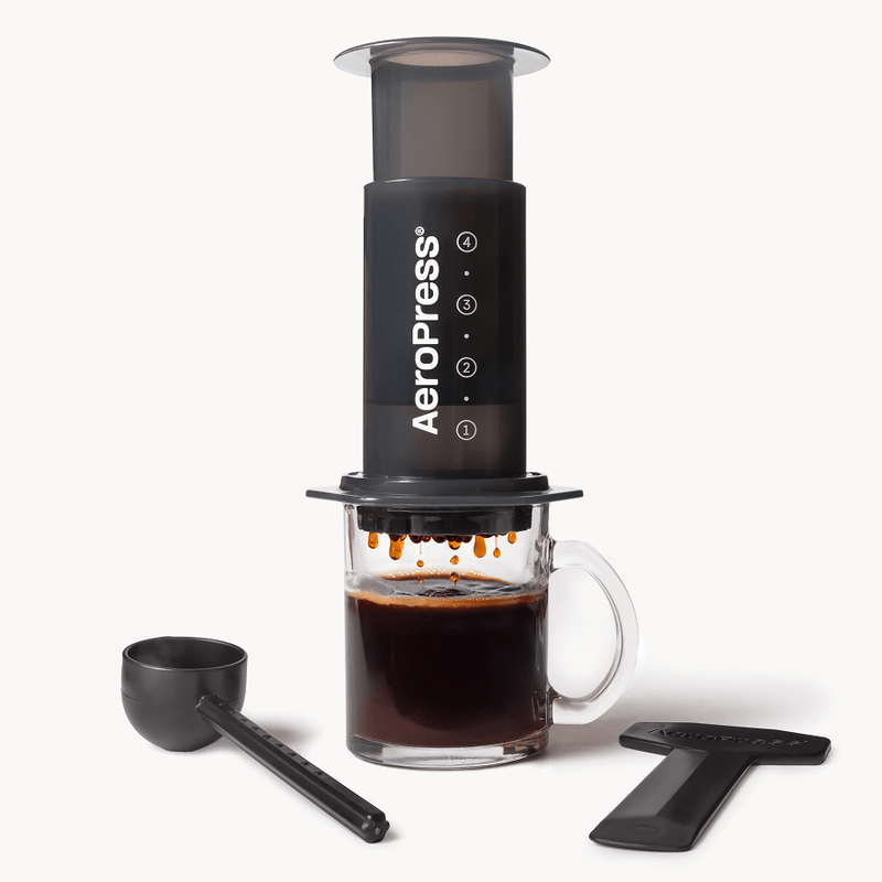 AeroPress Original with scoop and stirrer, shown over a glass mug; mug not included